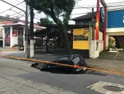 Carro estacionado é engolido por cratera no asfalt