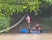 Pai atravessa rio com balsa adaptada para deixar f