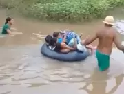 Crianças atravessam rio em boia para irem à escola