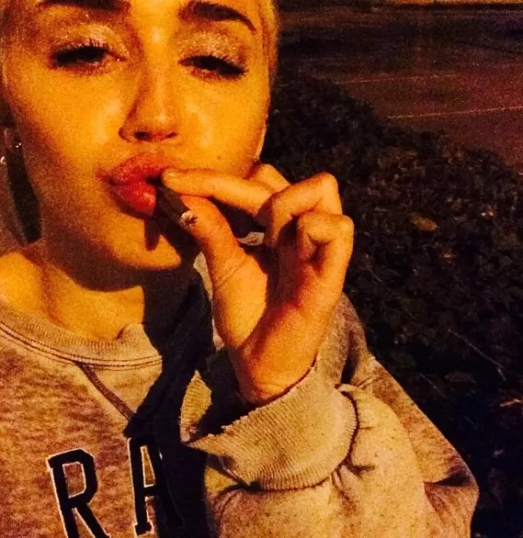 Miley Cyrus posa com cigarro suspeito na boca