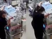 Enfermeiras protegem incubadoras com bebês durante