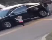 Menina de dois anos sai do carro e caminha com mão