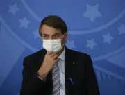Usando máscara, Bolsonaro sanciona lei que facilit